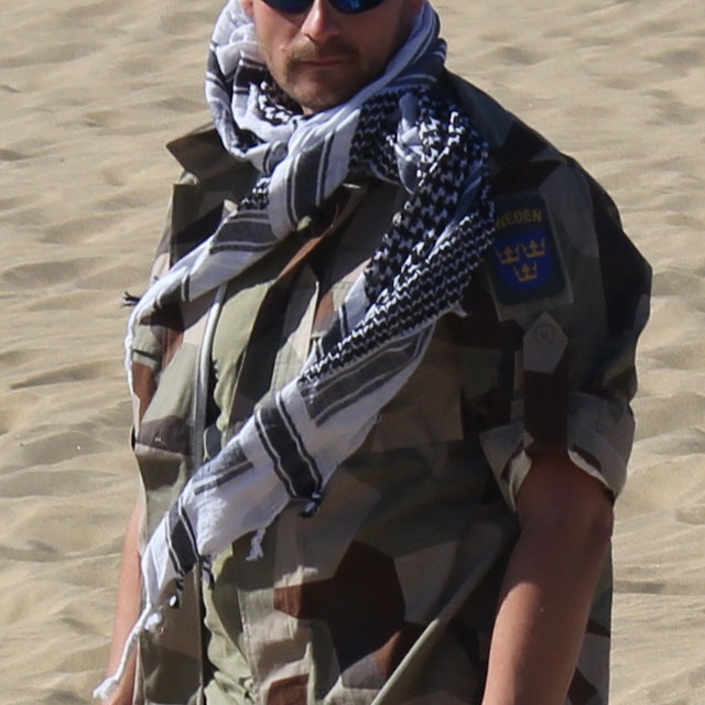 A Shemagh Black/White is worn together with a M90K Desert camouflage jacket in the sunny desert.