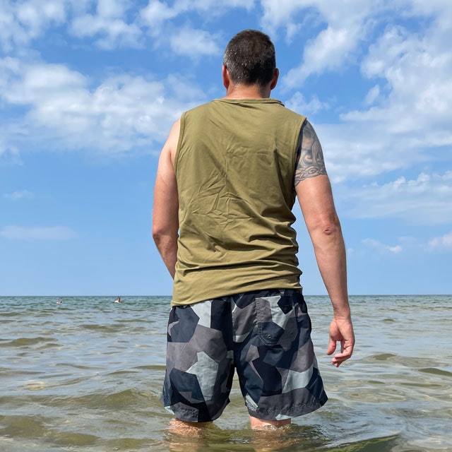 Tank Top Khaki Green from TAC-UP GEAR on model at the ocean seen from an angle of the back