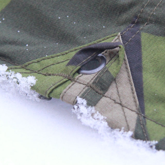 Eyelet and loop on the side of a Tarp Poncho M90.