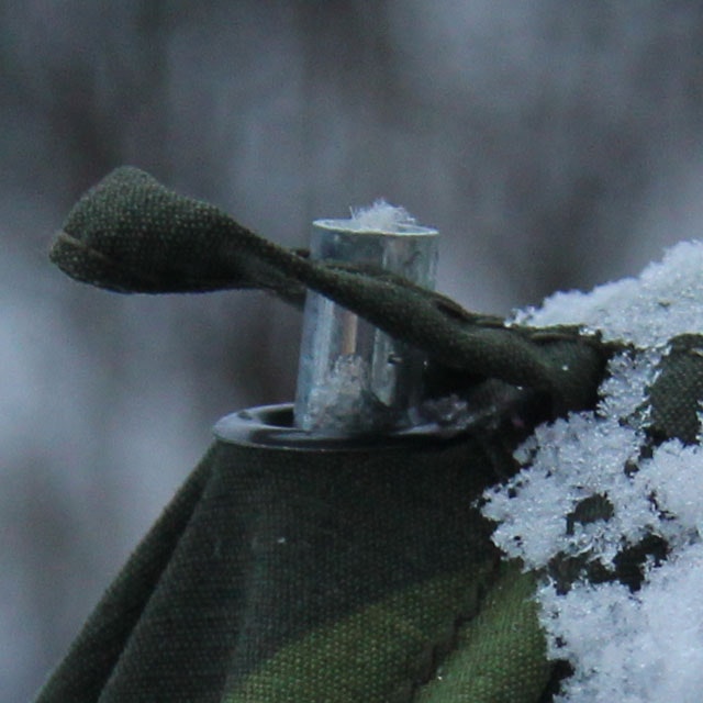 Close up on eyelet and loop on a Tarp Poncho M90.