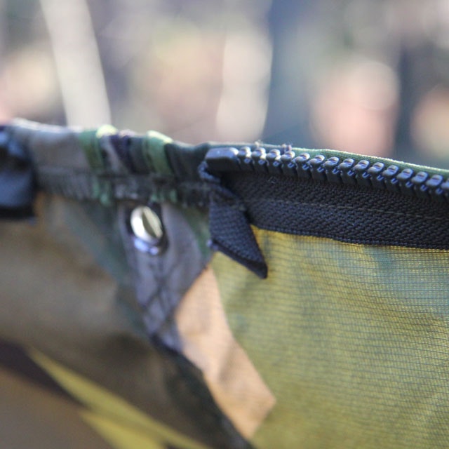 Close up of zipper and eyelet on a Tarp Poncho M90.
