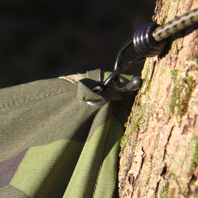 Use elastic rope and hooks to easily fasten the Tarp Poncho M90 in its eyelets.