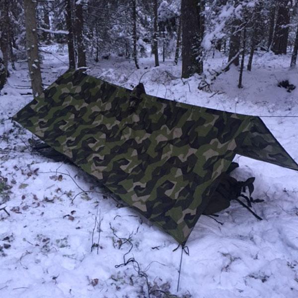 Shelter set up using a Tarp Poncho M90 in Swedish winter scenery.