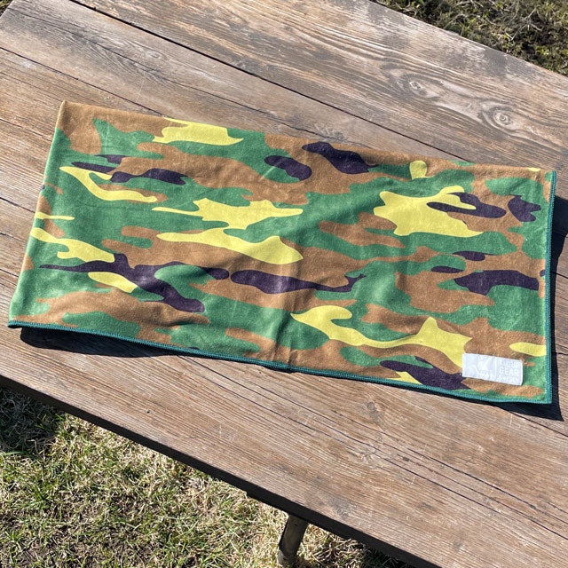 A Towel Camouflage from TAC-UP GEAR folded on a wooded table