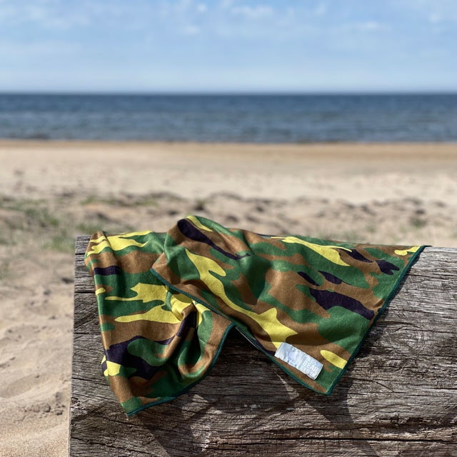 A Towel Camouflage from TAC-UP GEAR on a log at the beach