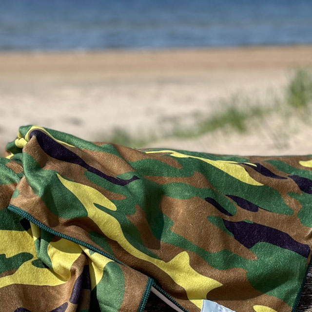 A closer look at a Towel Camouflage from TAC-UP GEAR lying on a log at the beach