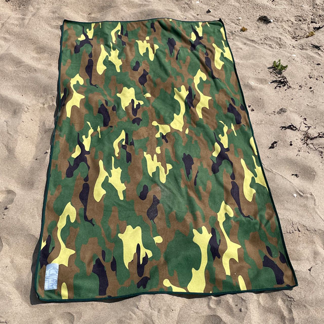 Towel Camouflage from TAC-UP GEAR lying flat on beach sand