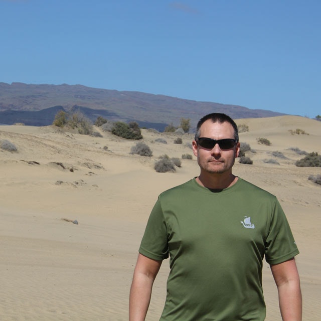 Training T-Shirt Green with mountains in the background.