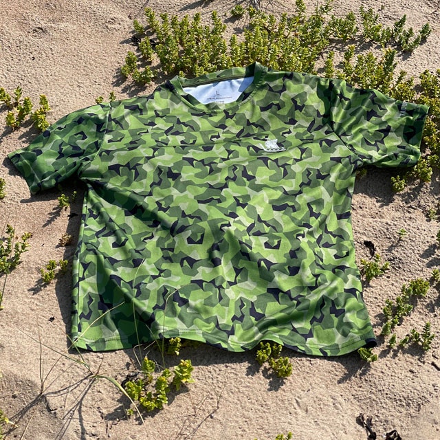 A Training T-Shirt M90 MI seen from a slight angle lying flat on the beach