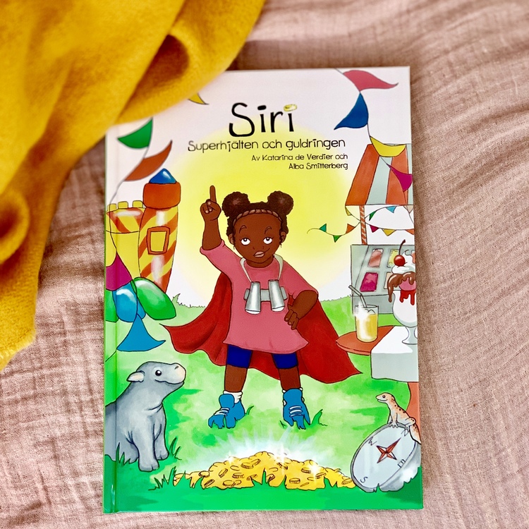 Barnbok Siri, Superhjälten och guldringen. Mångfald bland karaktärerna där mörkhyade barn och adopterade barn är representerade. Utspelar sig i Kenya. Författare Katarina de Verdier, Illustratör Alba 