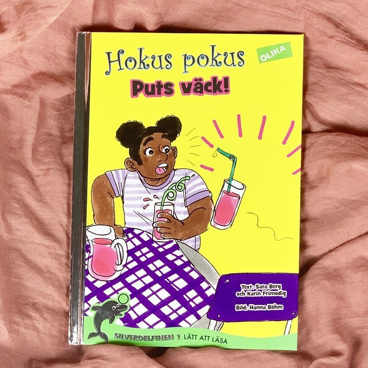 lätt att läsa bok, Hokus pokus: Puts väck! Författare Karin Frimodig & Sara Berg, Illustratör Hanna Böhm från Olika förlag. Mångfald bland karaktärerna där barn med mörk hy är representerade.