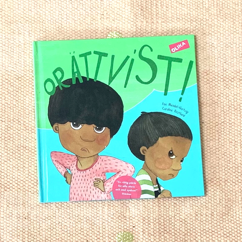 Boktitel Orättvist!, normkreativ bok där barn med mörk hy är representerade. Från Olika förlag, Författare Åsa Mendel-Hartvig, illustratör Caroline Röstlund