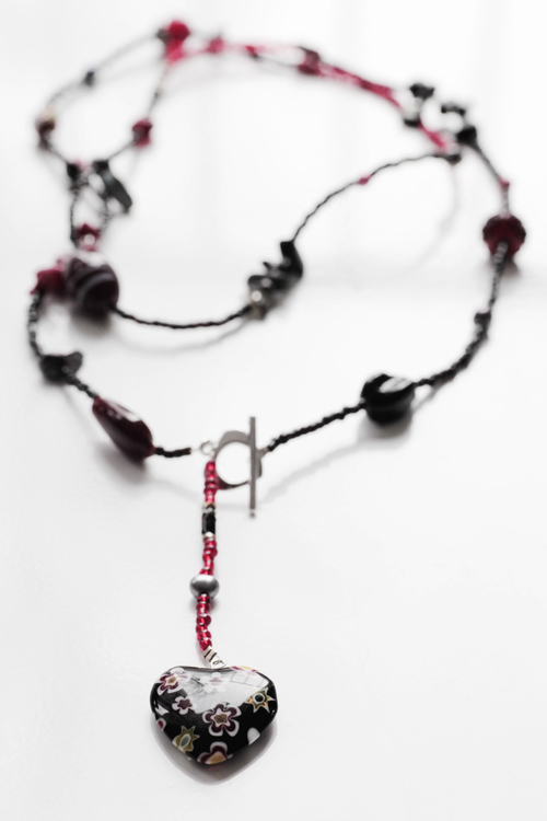 Långt pärlhalsband i svart och rött med millefiorihjärta