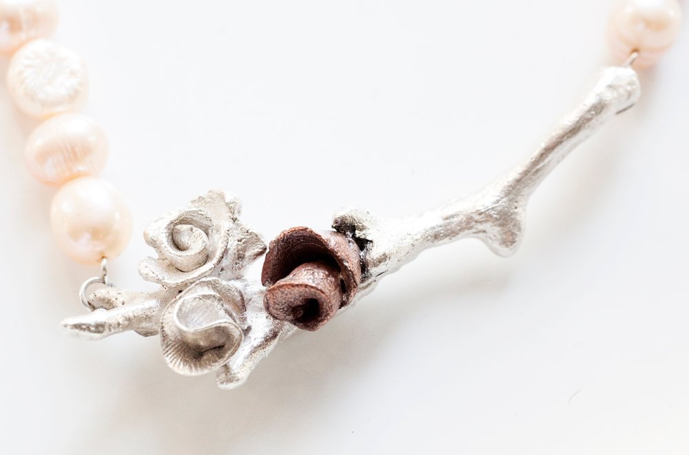 Silverkvist med rosor i silver och koppar på pärlhalsband i aprikos