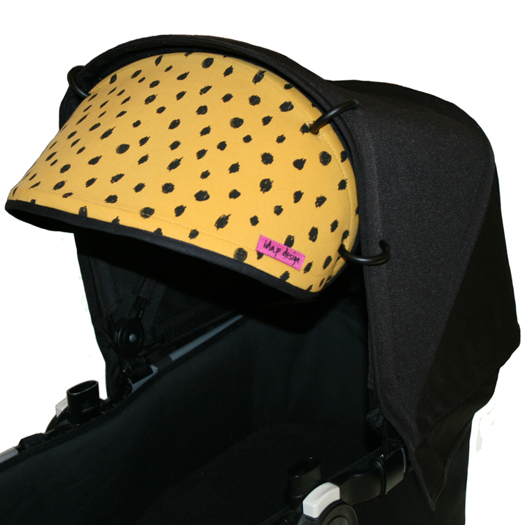 Solskärm för barnvagn i senapsgult tyg med svarta prickar