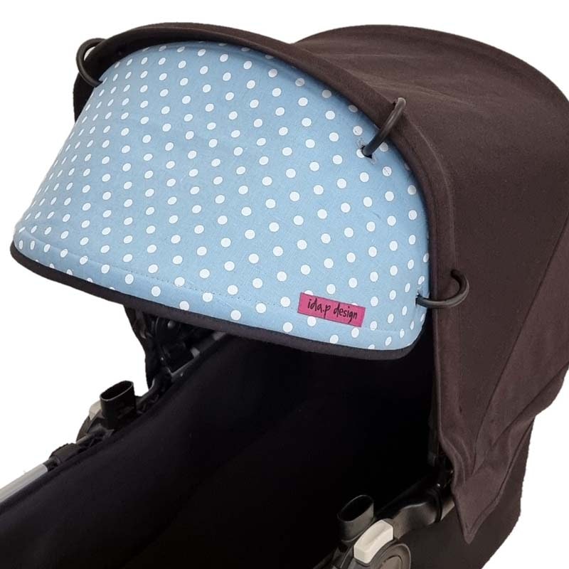 Solskydd till barnvagn i blått tyg med vita prickar
