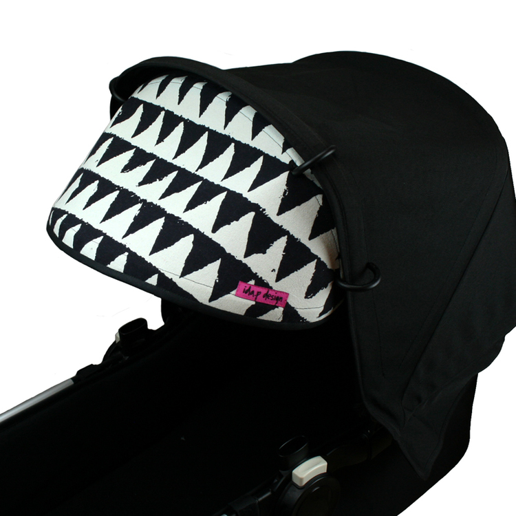 Solskydd till barnvagn i svart och vitt mönstrat tyg med trianglar.