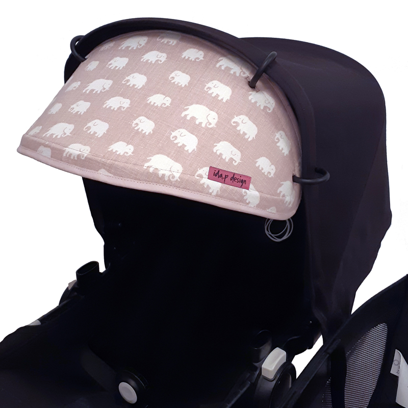 Solskydd för barnvagnar i rosa svenskt tenn tyg med elefanter. Rosa kantband och benvit baksida