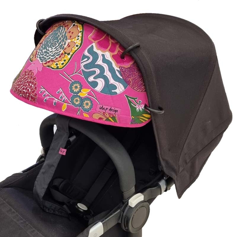 Solskydd barnvagn med ceriserosa tyg med asieninspirerat mönster