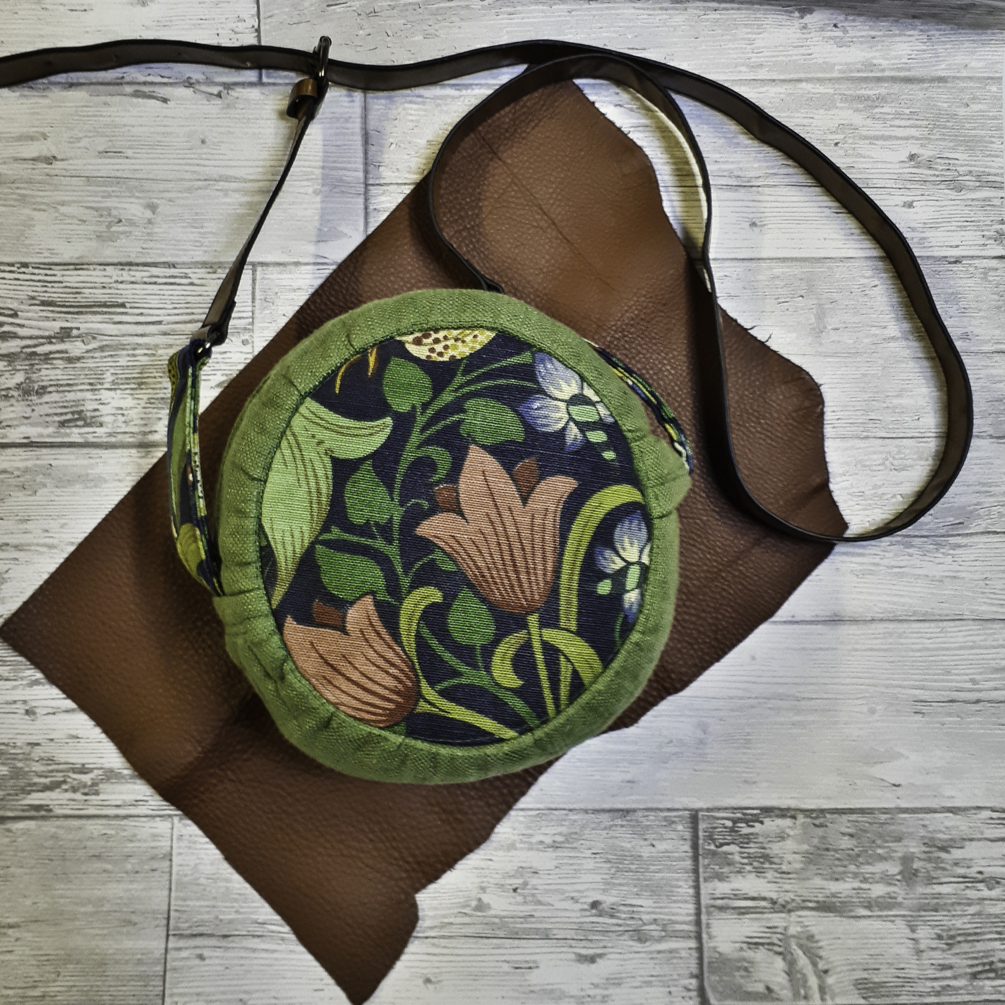 Rund väska i gröna mönster nyanser med ljusbrun läderrem