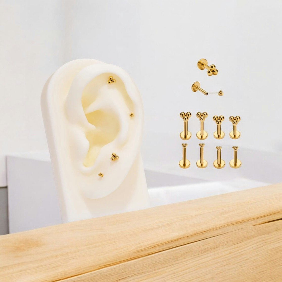 Threadless labret 1.2mm i guld PVD-pläterad titanium med bollkluster treenighet