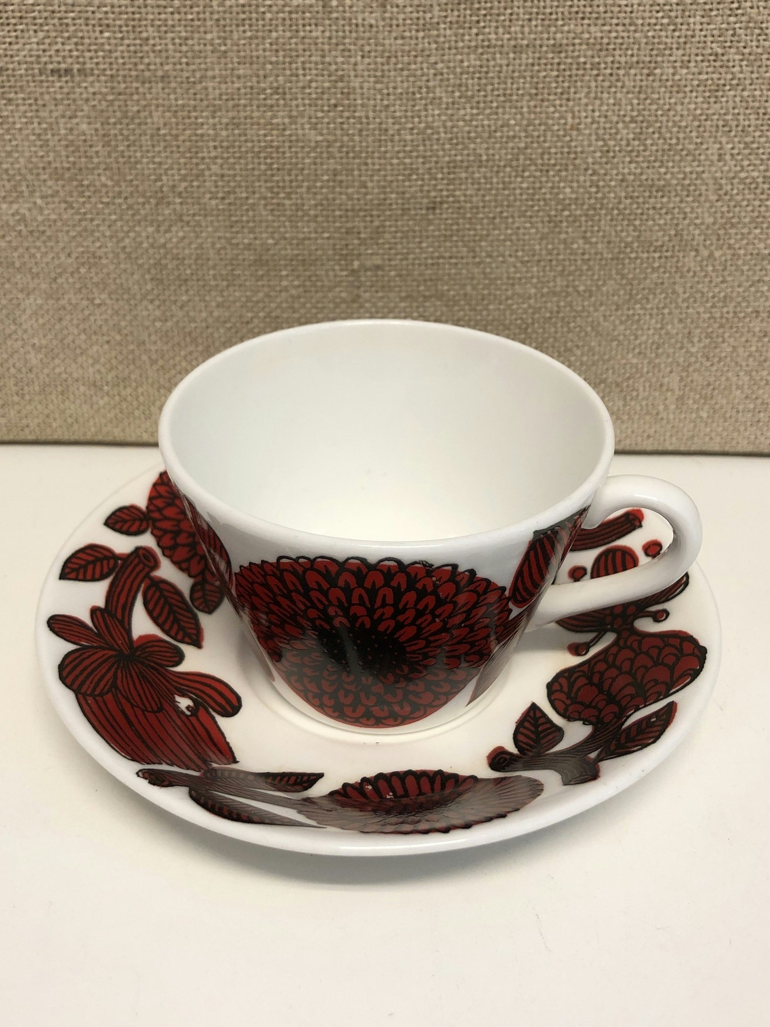 STIG LINDBERG. Kaffekopp med fat, benporslin, "Röd Aster", Gustavsberg.