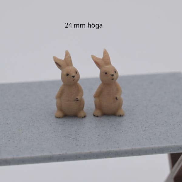 Kanin som sitter och har hand på magen 24 mm hög