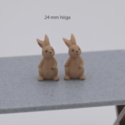 Kanin som sitter och har hand på magen 24 mm hög