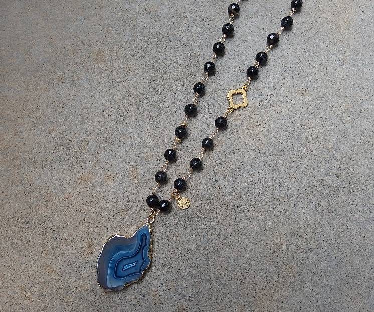Pärlhalsband i svart och blått med länkade pärlor.