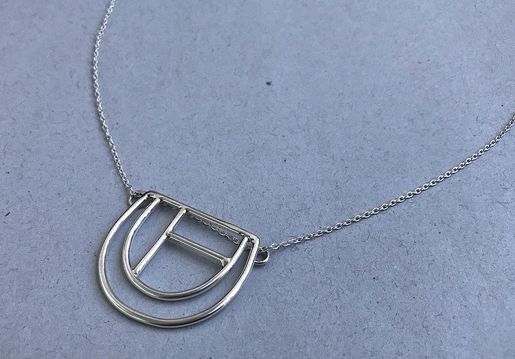 Modernt silverhalsband med krumelur hänge.