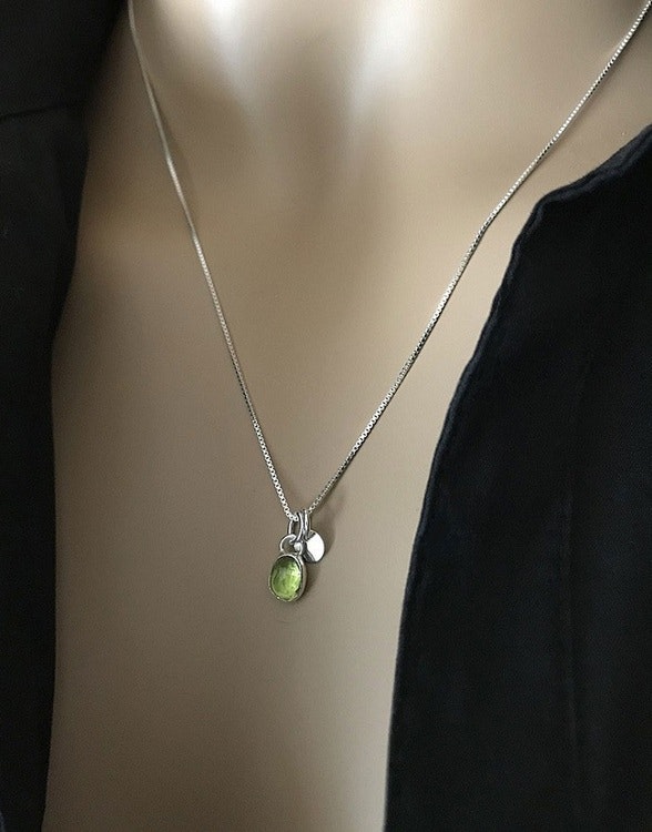 Silverhalsband med liten peridot sten och rund berlock