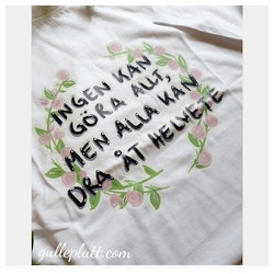 Vit T-shirt Blomkrans, med citatet "Ingen kan göra allt, men alla kan dra åt helvete"