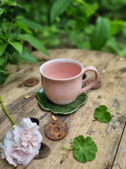 Drejad kopp i stengods med rosa glasyr, Mårbacka-pelargon som inspiration, keramikfat i form av ett pelargonblad, grön glasyr