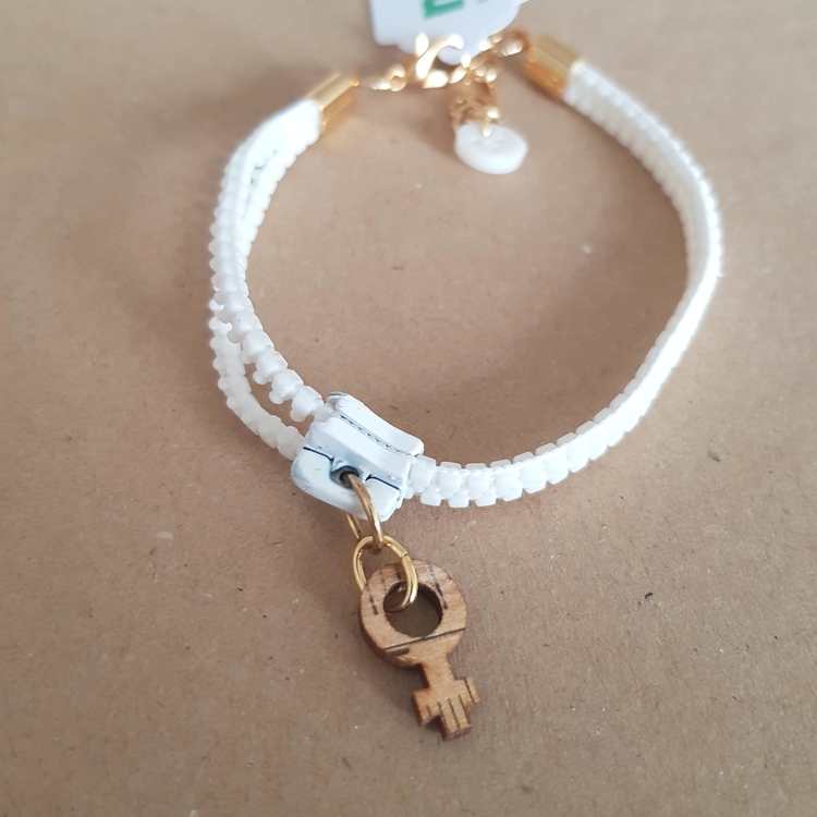 Armband blixtlås  - vitt/guldigt med feministsymbol