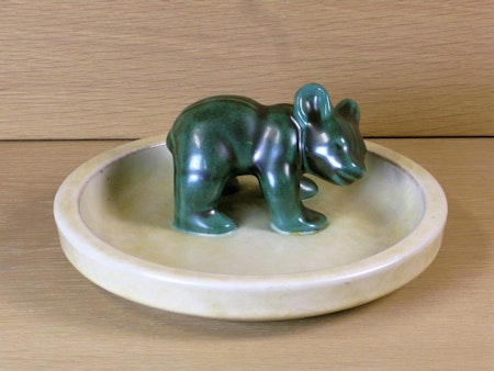 Green bear standing on dish