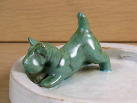 Green dog in a grey bowl