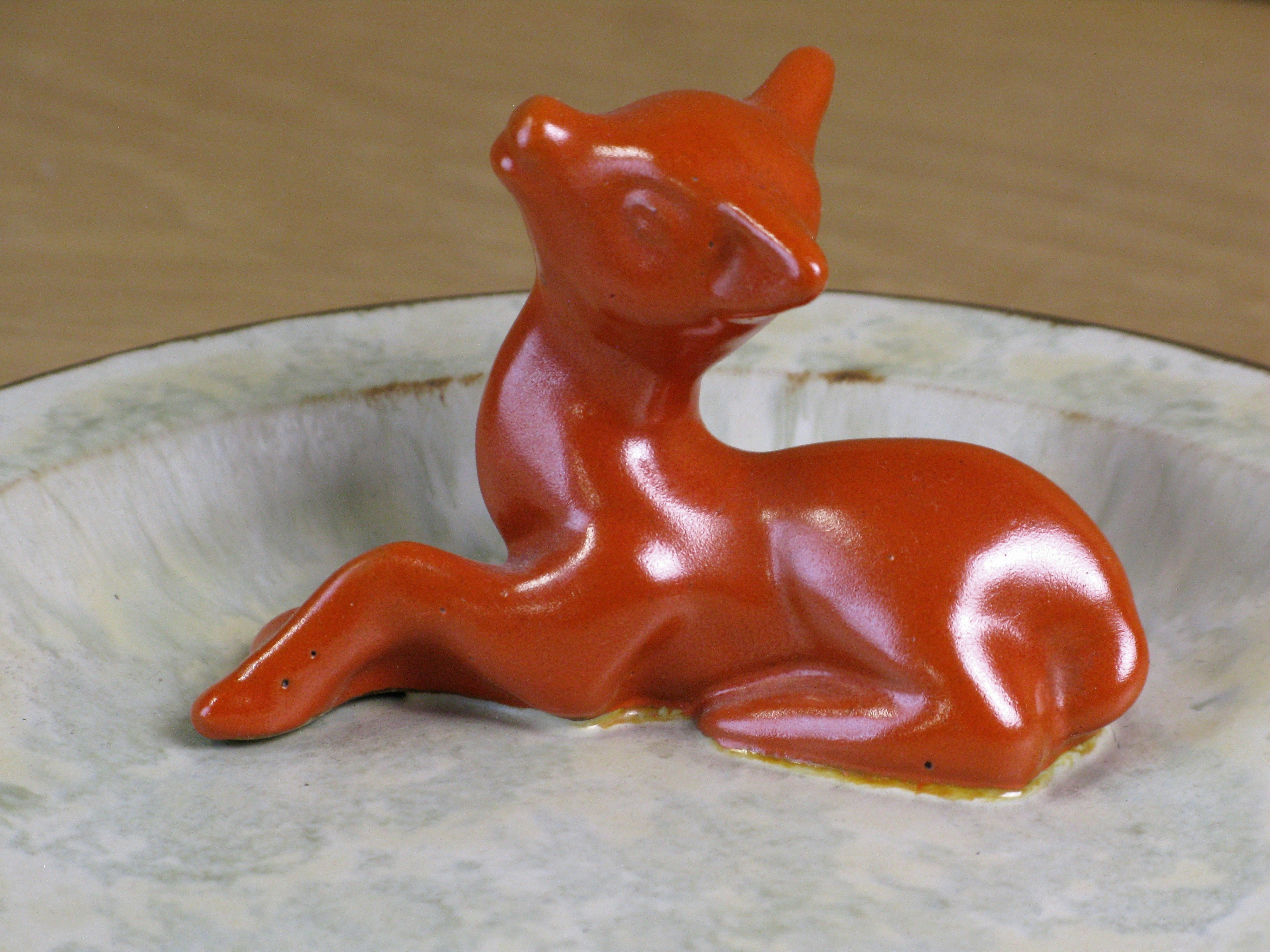 orange deer in greyish ashtray 46