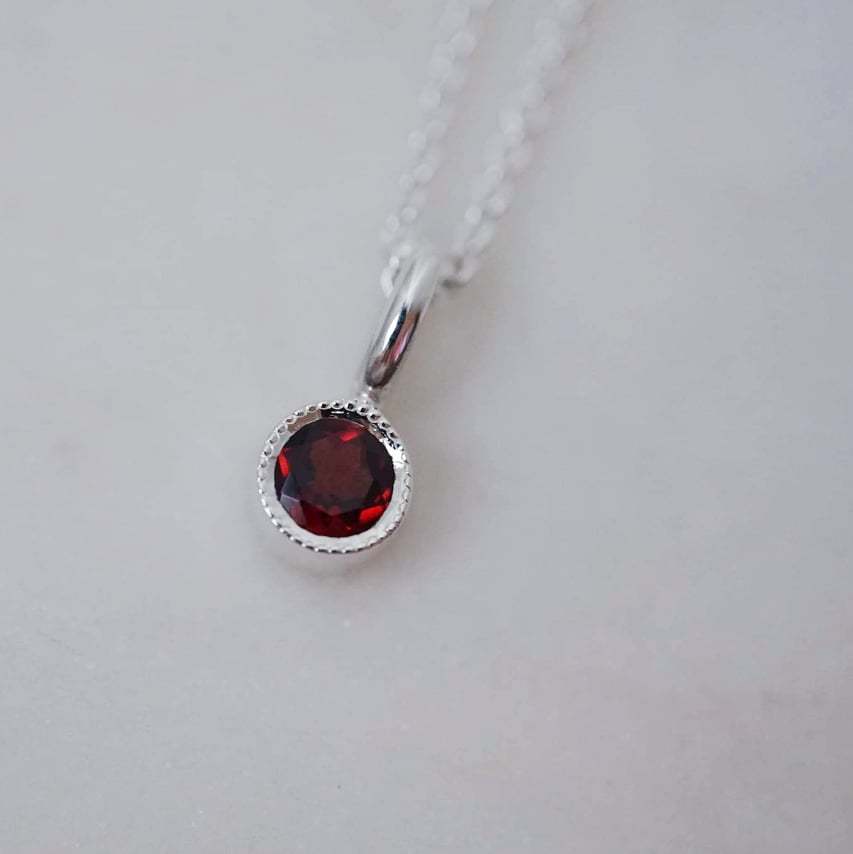 "Twinkle" pendant in silver with a red garnet