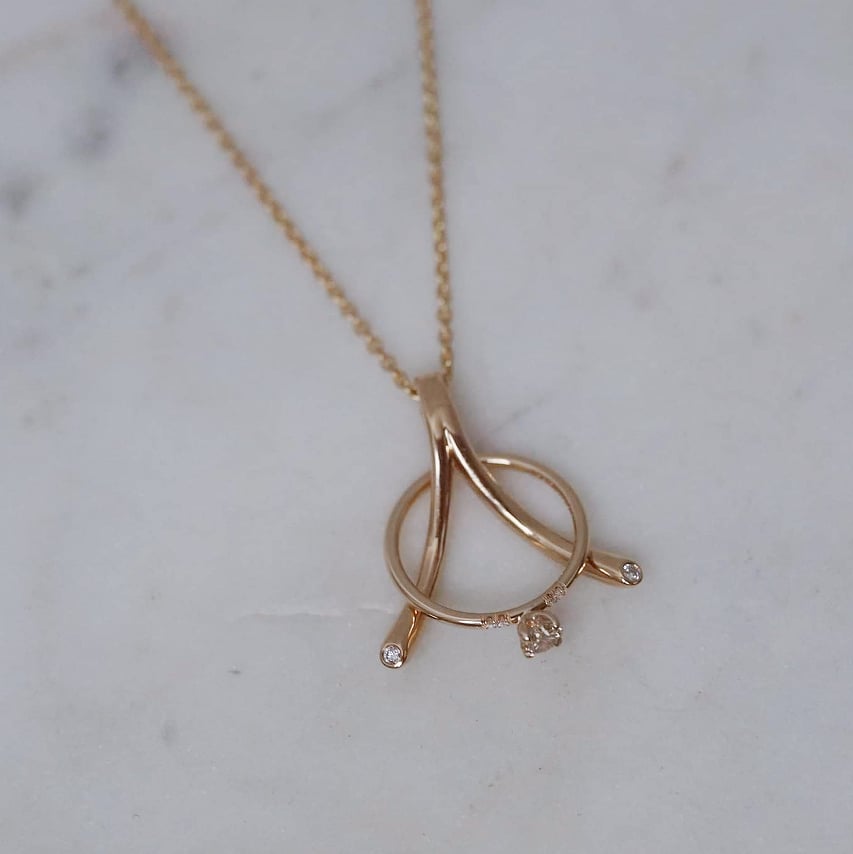 "Wishbone" ring holding pendant in gold with diamonds