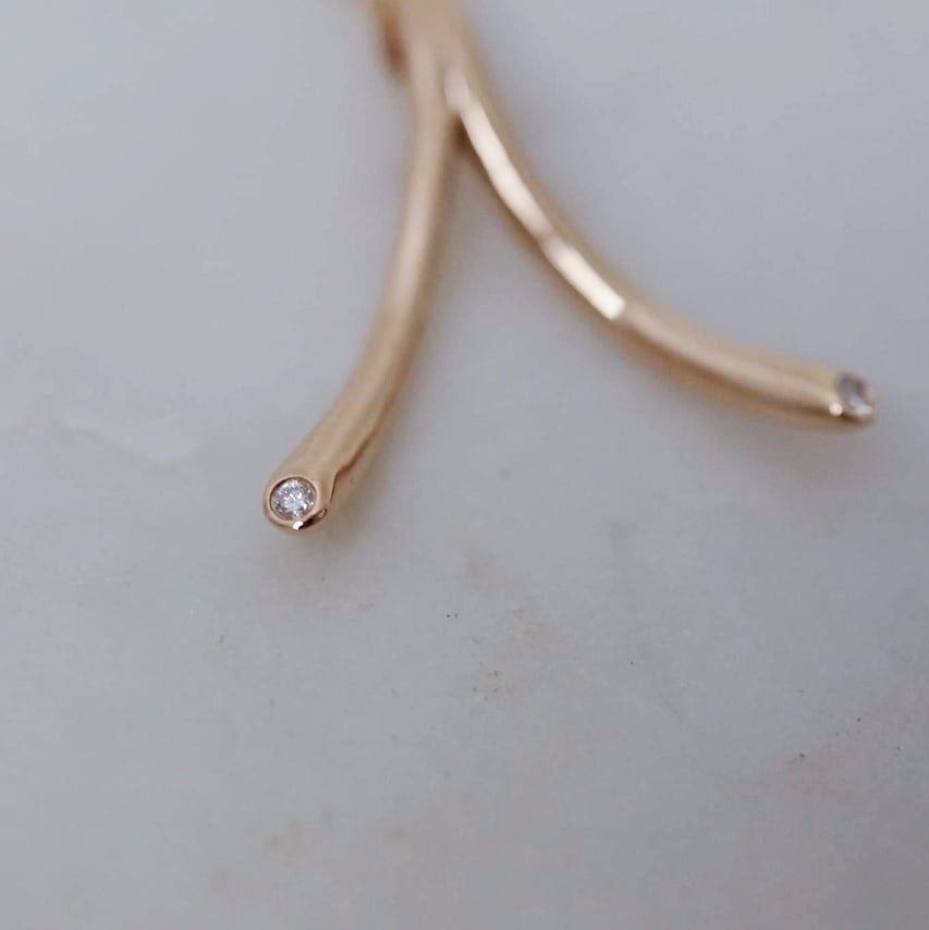 "Wishbone" ring holding pendant in gold with diamonds