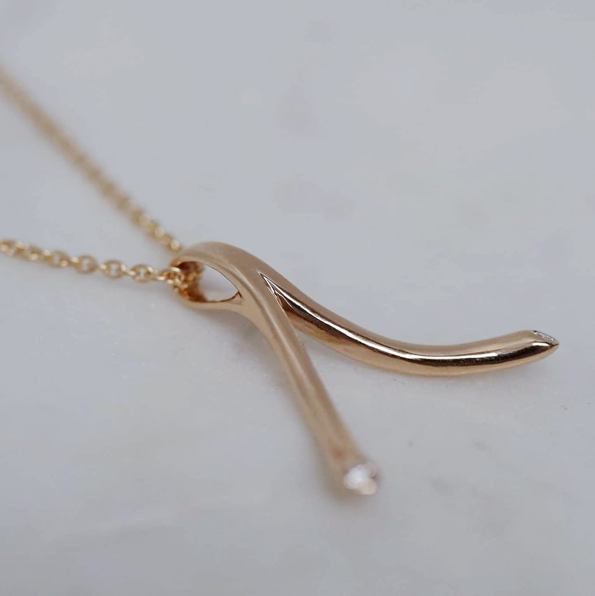 "Wishbone" ring holding pendant in gold with diamonds