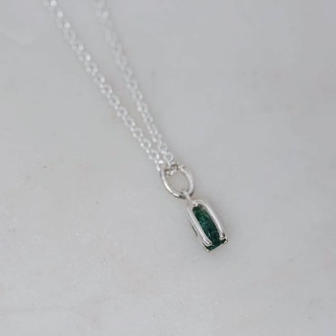 Pendant in silver with a raw emerald