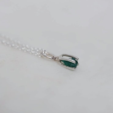 Pendant in silver with a raw emerald
