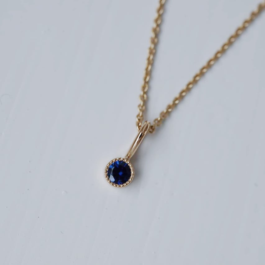 "Twinkle" pendant in gold with a blue sapphire