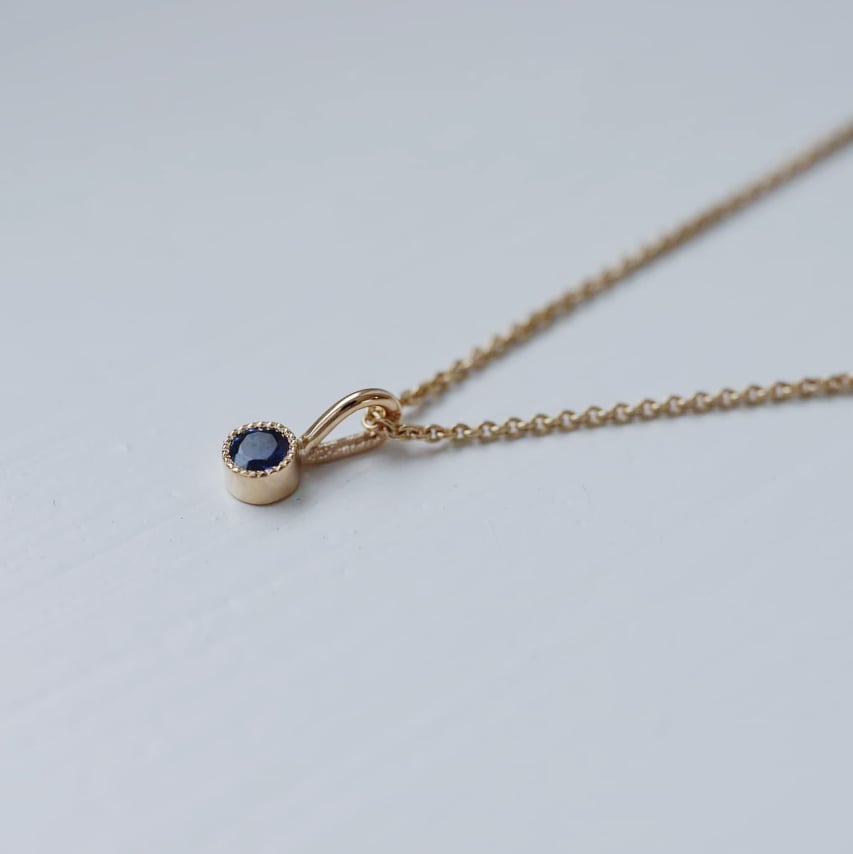"Twinkle" pendant in gold with a blue sapphire