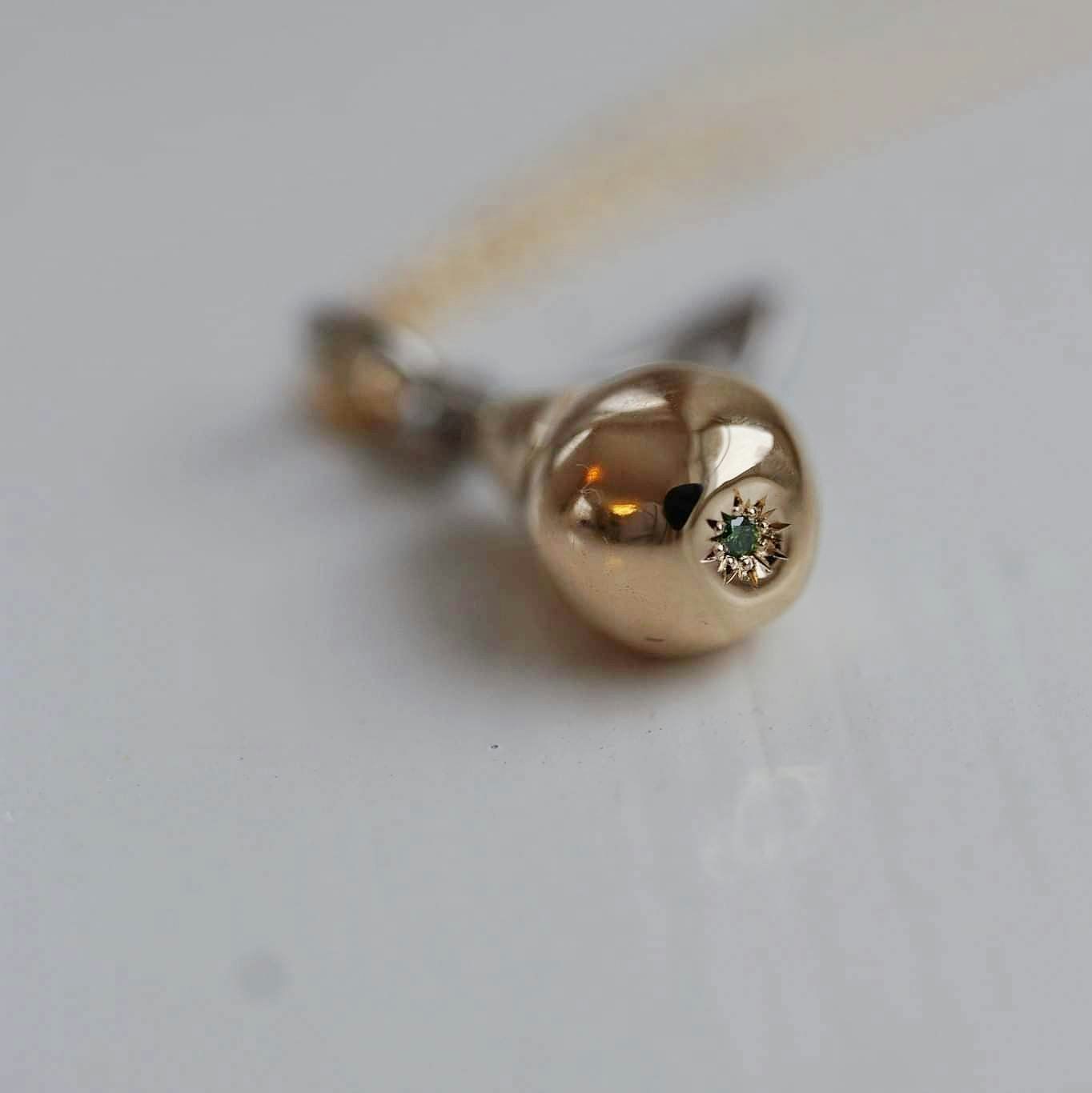 "Pear" in mixed gold with a green diamond