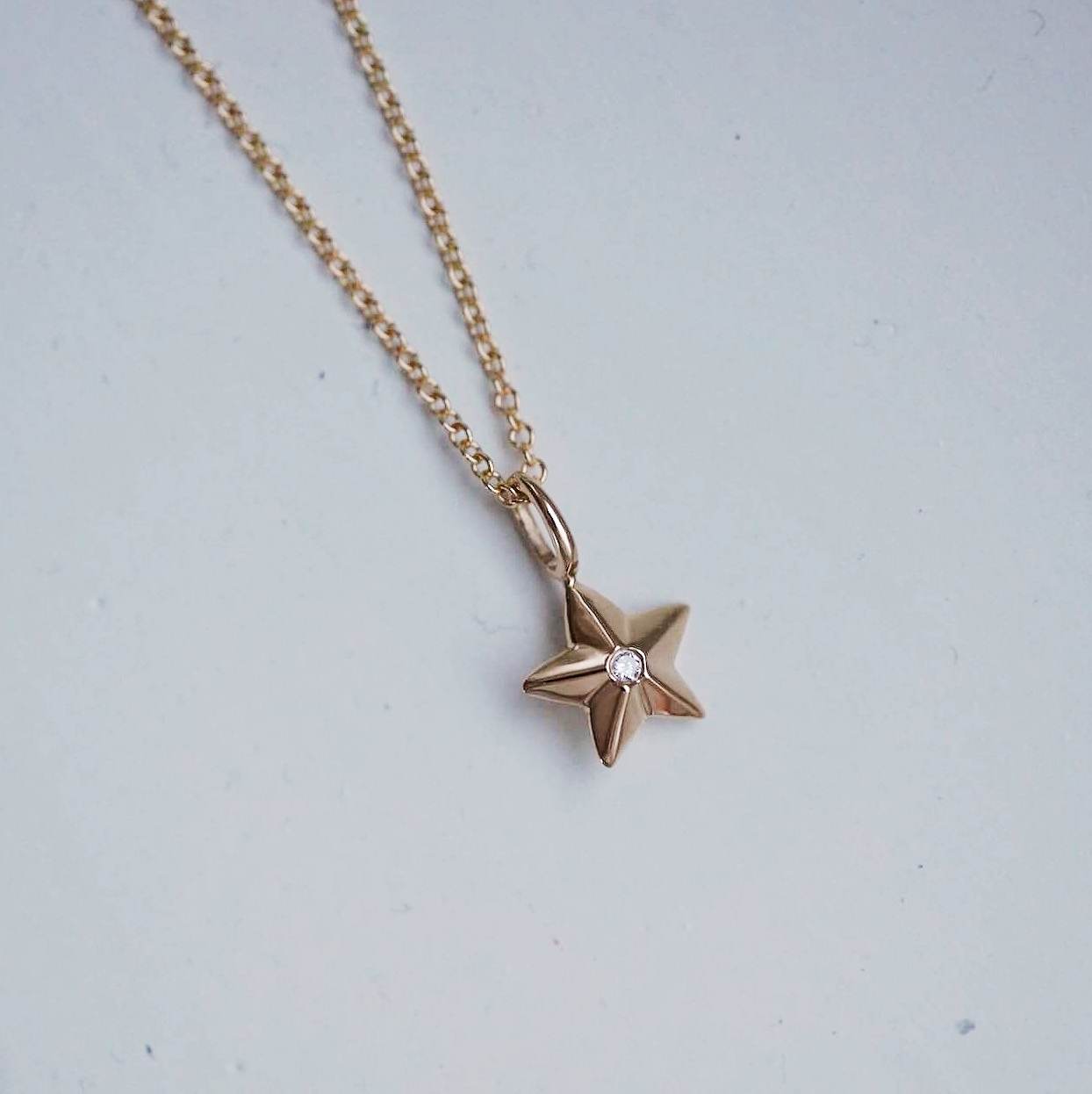 "Star" hänge i guld med en liten diamant