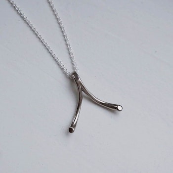 "Wishbone" ring holding pendant in white gold