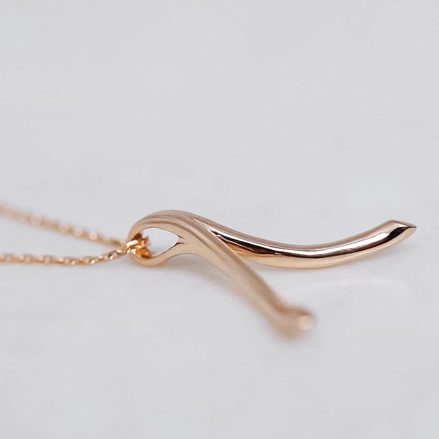 "Wishbone" ring holding pendant in gold