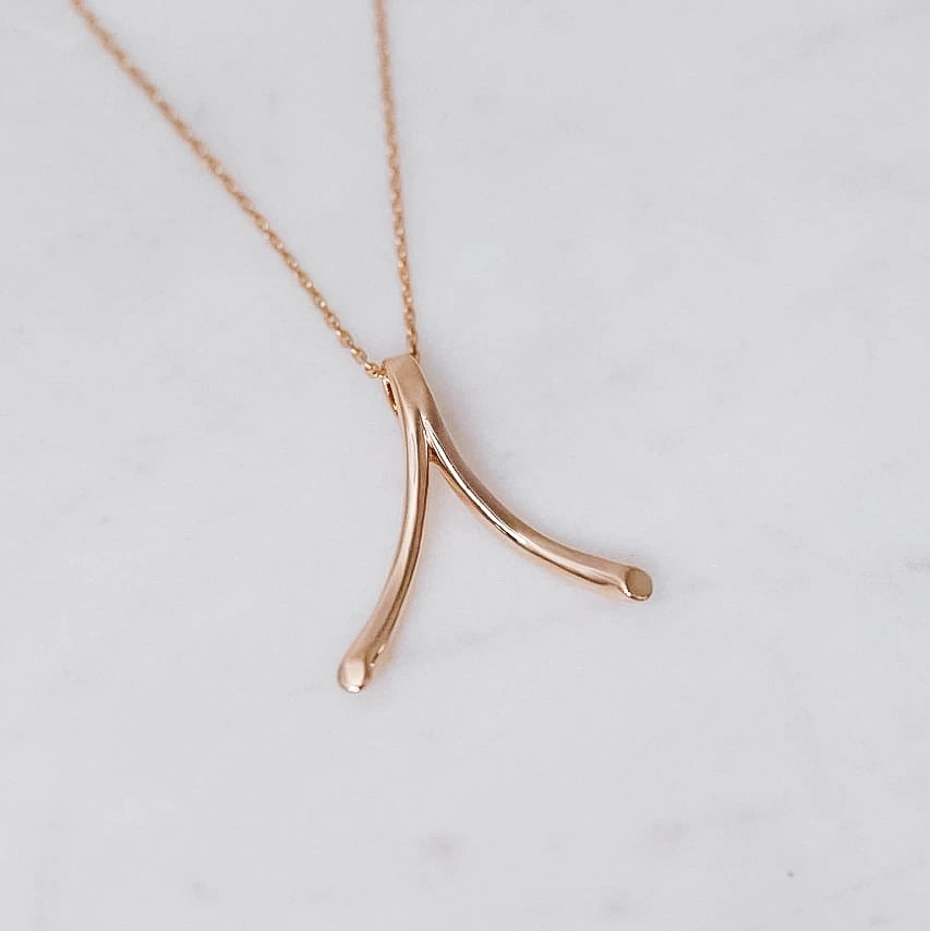 "Wishbone" ring holding pendant in gold